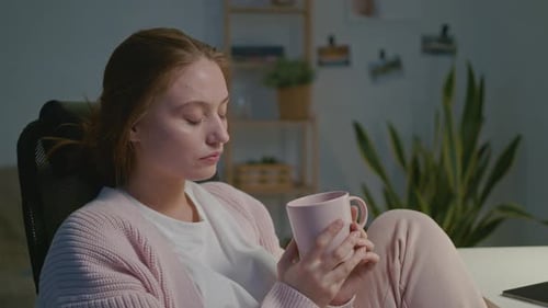 Müde Designerin trinkt aus einer Tasse
