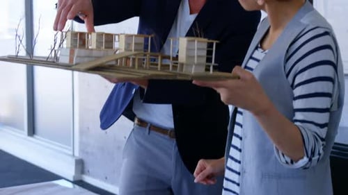 Caucasian business people discussing over factory model in modern office 4k