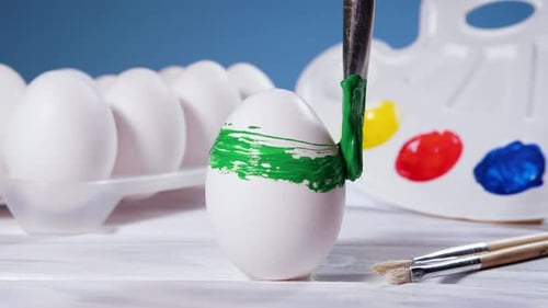 Painting Easter Eggs with a Green Brush Preparation for Spring Holiday Religious Celebration Art