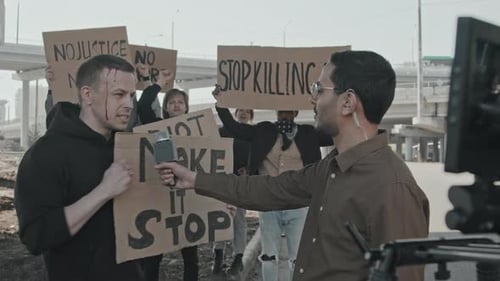 Un journaliste de télévision interroge un blessé lors d'une manifestation