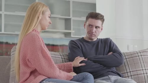 Young Couple Sitting on Couch, Arguing