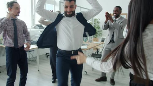 Slow Motion of Man in Formalwear Dancing in Office While Colleagues are Having Fun and Applauding