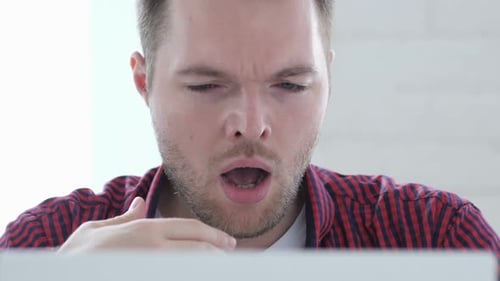 Hombre cansado en el trabajo tratando de relajarse frotándose los ojos