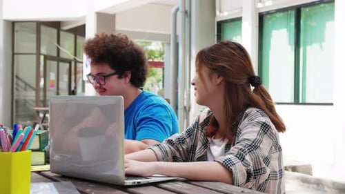 Students Collaborating on Laptop at Outdoor Table