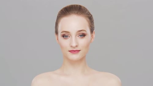 Studio portrait of young, beautiful and natural woman over grey background.