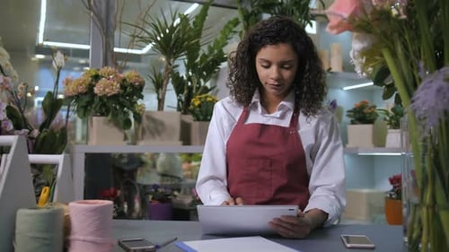 Florist Taking Orders Using Tablet in Flower Shop