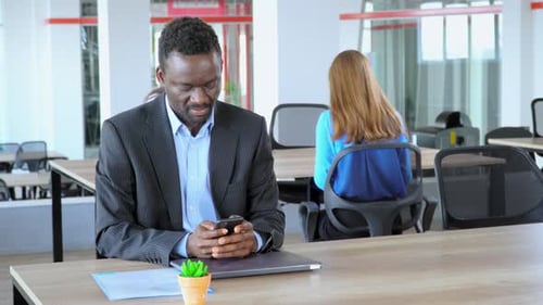 African American Manager Holding Smartphone Works in Open Space Office Worker in Start Up Company