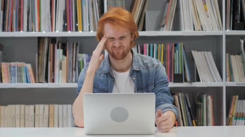 Upset Man Working on Laptop in Library