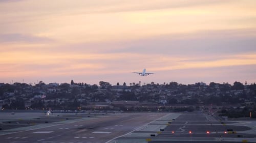 Airplane Taking Off at City Airport During Sunset