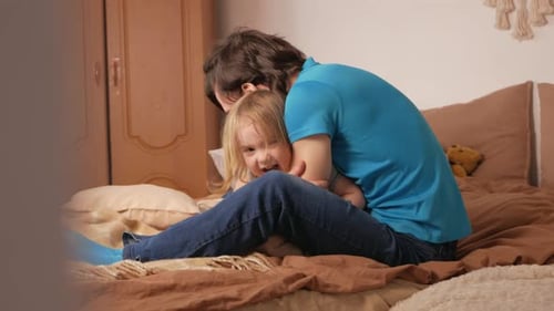 Father and Child Cuddling Affectionately on Bed