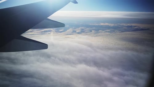 Vue rapprochée à travers la fenêtre de l'avion sur l'aile de l'avion et nuage blanc en dessous