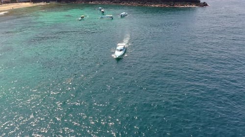 Boat Sailing in Crystal Ocean Waters with View of the Island Trees and Beach