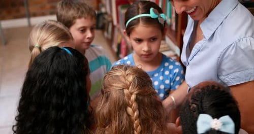 Schüler sprechen mit ihrem Lehrer in der Bibliothek
