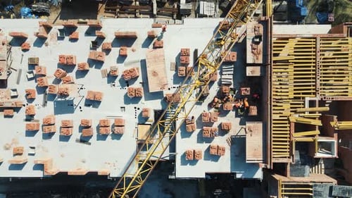 Vue aérienne de dessus sur la construction d'une maison en briques rouges à plusieurs étages