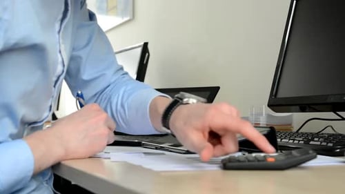 Young Handsome Man Works in the Office (Writing and Works on Tablet) - Closeup