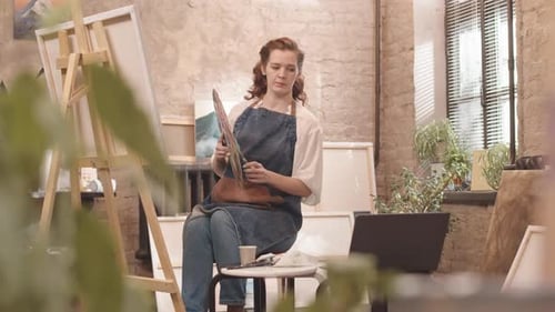 Woman Painting in Sunny Urban Studio