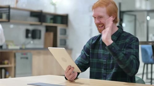Online Video Chat on Tablet By Beard Redhead Man in Cafe