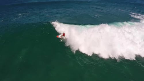 Aerial view of a man sup stand-up paddleboard surfing in Hawaii