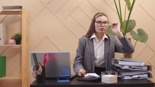 Tired Female Office Worker Lays Head on Stack Document Folders Front View