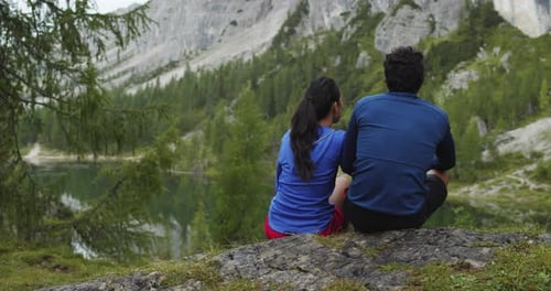 Woman and Man Couple in Love Hugs Near Lake From Behind