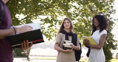 Mann, Student mit ausgeschnittener Ansicht, hält Lehrbuch im Freien