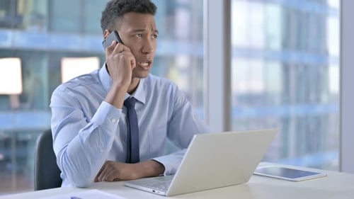African American Businessman Talking on Smartphone in Office