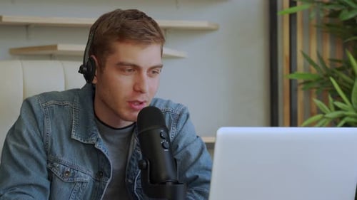 Young Adult Recording Audio on Laptop with Microphone