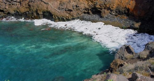 View of Ocean Waves Break on Rocks of Tenerife Island Cliffs in a Blue Ocean
