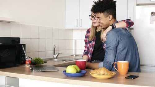 Affectionate Couple Using Laptop in Kitchen