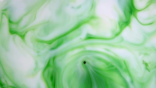 Footage. Ink in Water. Green Ink Reacting in Water Creating Abstract Background.