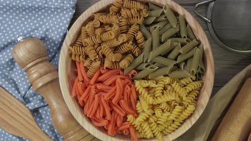 Multicolored Pasta Rotating in Slow Motion Top View. Rotation of Colored Spiral Pasta