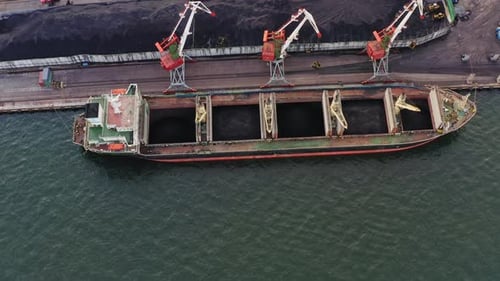 Bulk Carrier is Loaded with Coal in the Port Using Cranes