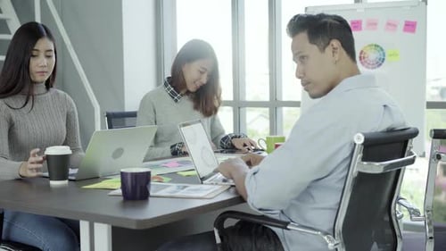 Team Collaborating on Laptops in Modern Office