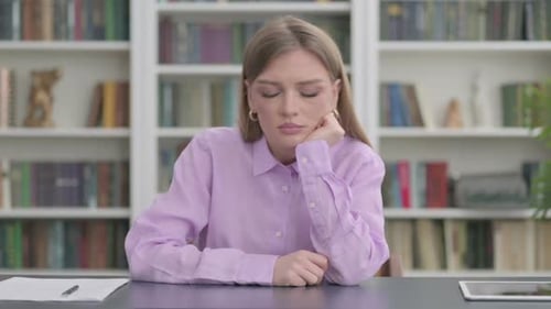 Tired Woman Sleeping While Sitting in Office