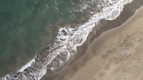Ocean Waves Crashing onto Sandy Beach Aerial View