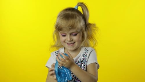 Kid Playing with Hand Made Toy Slime. Child Having Fun Making Turquoise Slime. Funny Pupil Girl