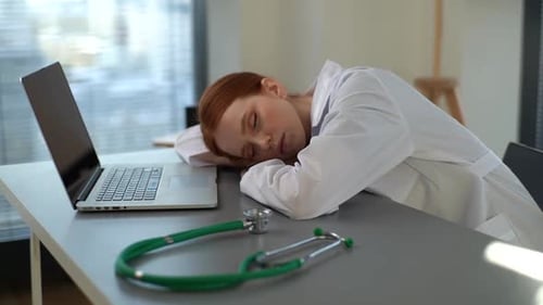 Tired Doctor Resting at Desk in Office