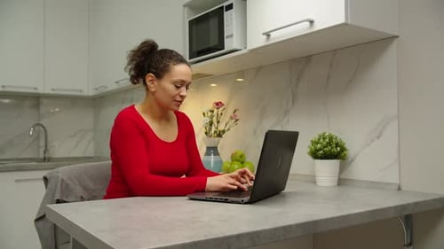 Woman Using Laptop in Modern Kitchen