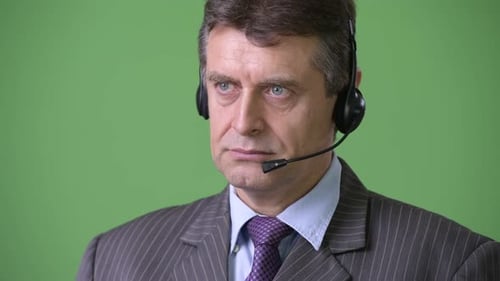 Mature Handsome Businessman Against Green Background