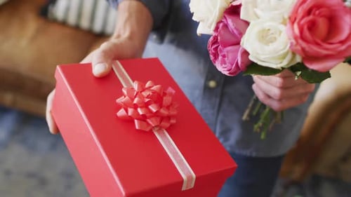 Man Holding Red Gift Box and Bouquet of Roses