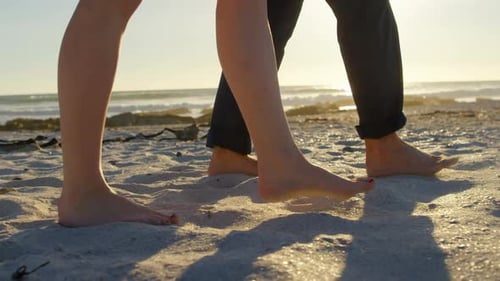 Low section of couple walking at beach on a sunny day 4k