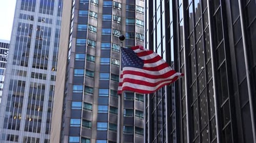 American Flag Waving Between City Skyscrapers