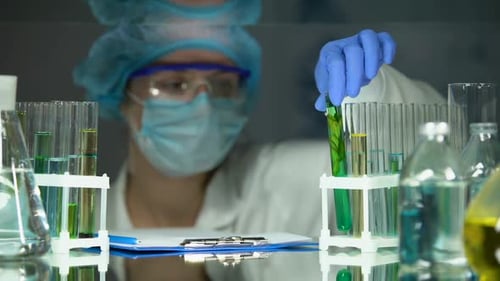 Un biologiste analyse une plante dans un agent de conservation vert Rédaction des résultats d'expériences