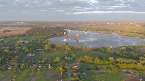 Hot Air Balloons Soaring Over Lake and Countryside