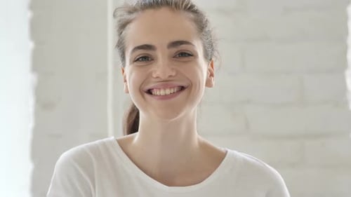 Hallo, junge Frau winkt mit der Hand zur Begrüßung