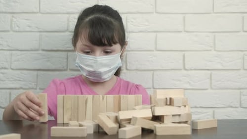 Child Playing With Blocks While Wearing Mask