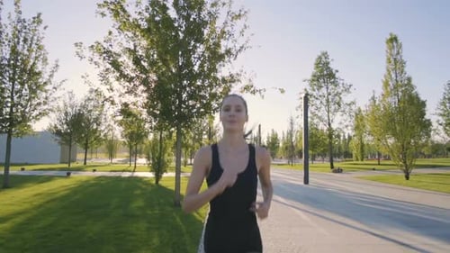 Sports Woman Makes Morning Jog and Physical Exercises In Park