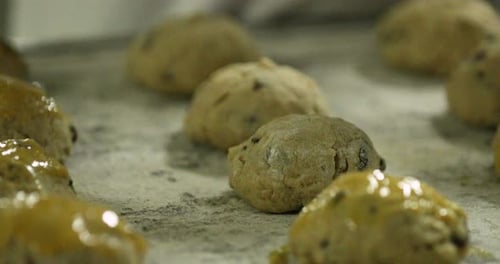 Bäcker, der vor dem Backen Eier mit einem Backpinsel auf ein Tablett aufträgt - Zeitlupe