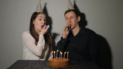 Happy Couple Celebrating Birthday with Cake and Favors