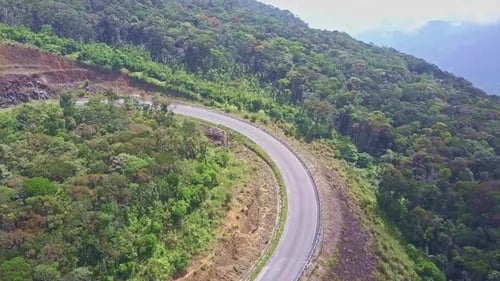 Zumbido vuela sobre la curva de una carretera montañosa